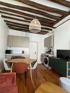 a kitchen and dining room with a table and chairs at L'Ecrin Bellifontain - Appartement Confort - Centre in Fontainebleau