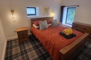 a bedroom with a large bed with red sheets and a window at 3 Bed House - Sea Views Balcony Parking Pets in Innellan