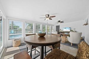a living room with a wooden table and chairs at Manatee Cove Waterfront Home w Dock Pool in Cocoa Beach