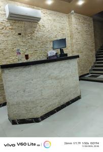 Un mostrador de recepción con un televisor en una pared de ladrillos. en Pyramids zh inn, en El Cairo