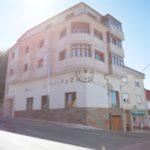 a large white building with a clock on it at Zendoira in Palas de Rei