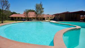 图兰辛戈Foresta Camp, Habitaciones y Hostales en el Bosque的房子前面的一个大游泳池