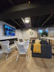 a living room with a couch and chairs and a television at Spot Caché - Private Waterfront Cottage in Papineauville