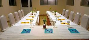 una larga mesa blanca con sillas en una habitación en LMS Palve Sugavasam, en Ooty