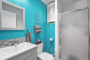 a bathroom with a toilet and a sink and a shower at The Leon Lane Oasis w Pool Fire Pit Steps to the Beach in Cape Canaveral