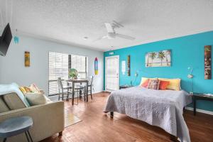 a bedroom with blue walls and a bed and a table at The Leon Lane Oasis w Pool Fire Pit Steps to the Beach in Cape Canaveral