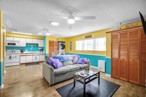 a living room with a couch and a kitchen at The Leon Lane Oasis w Pool Fire Pit Steps to the Beach in Cape Canaveral +37 photos