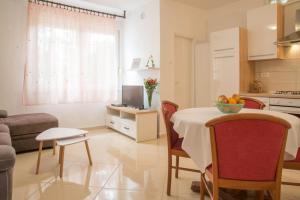 eine Küche und ein Wohnzimmer mit Tisch und Stühlen in der Unterkunft Complex 21 in Mali Lošinj