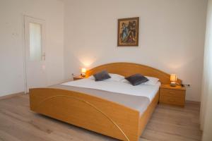 ein Schlafzimmer mit einem Holzbett mit zwei Kissen in der Unterkunft Complex 21 in Mali Lošinj