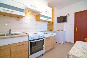 eine Küche mit Herd und Spüle in der Unterkunft Complex 21 in Mali Lošinj + 38 Fotos