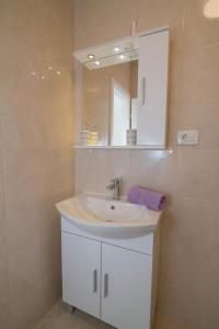 ein Badezimmer mit Waschbecken und Spiegel in der Unterkunft Complex 21 in Mali Lošinj