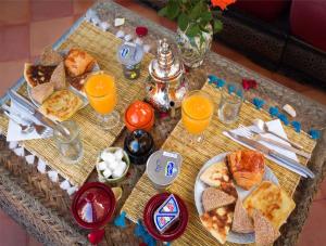 a table with a tray of food and glasses of orange juice at Oasis apartment in Ouarzazate