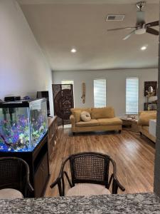 sala de estar con sofá y pecera en Family house close airport & Lewisville Lake!, en Lewisville