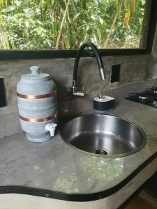 a kitchen counter with a sink and a window at Floresta das Evas in Petrópolis