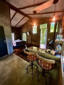 a room with a counter and two bar stools at Floresta das Evas in Petrópolis