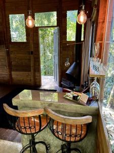 a kitchen with a counter and two chairs at a table at Floresta das Evas in Petrópolis