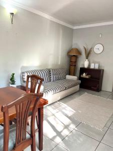 a living room with a couch and a table at De Valk & Tak Manor in Bloemfontein