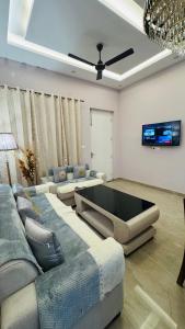 Una sala de estar con dos sofás y un televisor. en Orchid Highland, en Dehradun