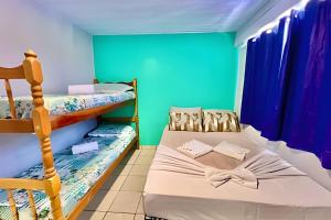 a bedroom with two bunk beds and blue walls at #PaRtiU PrAiA, 50 passos do Mar in Matinhos