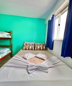 a bed in a room with a green wall at #PaRtiU PrAiA, 50 passos do Mar in Matinhos +25 photos