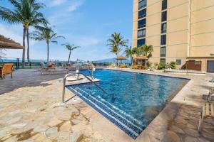 a pool at a resort with palm trees and a building at Mahana 602 · MA 602 Kaanapali OceanFront Studio Ocean View Pool in Kahana