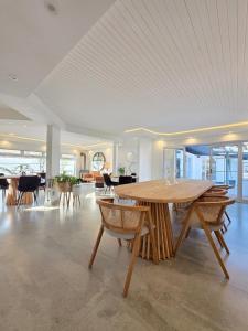 White Cottage Boutique Guesthouse في سواكوبموند: غرفة كبيرة مع طاولة وكراسي خشبية