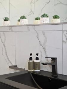 White Cottage Boutique Guesthouse في سواكوبموند: زجاجتان من الروائح تقعان على حوض الحمام