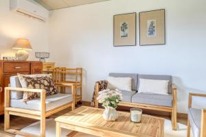 a living room with a couch and chairs and a table at O Miminho, a Home in Madeira in São Jorge