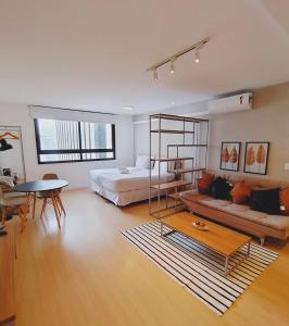 Una sala de estar con una cama, un sofá y una mesa. en Boutique Send Rio by Bstay, en Río de Janeiro