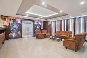 Una sala de espera con sillas, una mesa y cortinas. en Super Townhouse Divya Palace, en Indore