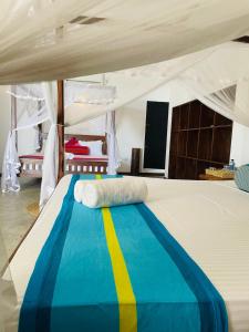 ein Bett in einem Zelt mit einer gelb-blauen Decke in der Unterkunft Hotel Emanuel Kabalana in Piyadigama