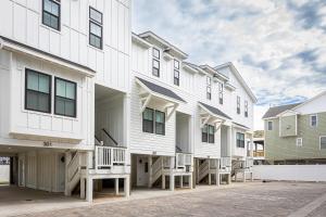 a row of white apartment buildings with balconies at THAT House - NEW Oceanview Steps to the Beach in Kill Devil Hills
