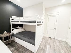 a bedroom with bunk beds in a white room at THAT House - NEW Oceanview Steps to the Beach in Kill Devil Hills