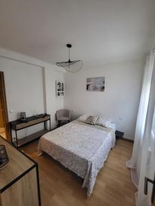 biała sypialnia z łóżkiem i żyrandolem w obiekcie Escapade en plein cœur Antibes w mieście Antibes