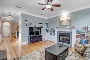 un soggiorno con camino e ventilatore a soffitto di Aqua Vista - Cozy beach home w BBQ & large deck a St. Augustine