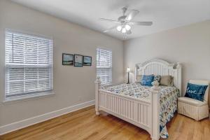 una camera con letto bianco e ventilatore a soffitto di Aqua Vista - Cozy beach home w BBQ & large deck a St. Augustine