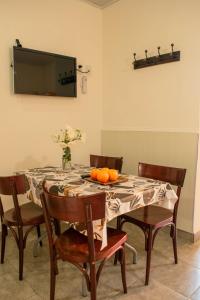 a dining room table with a vase of oranges on it at LOS GURISES Villa Elisa in Villa Elisa +8 photos