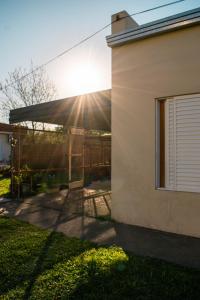 a building with the sun shining under a tent at LOS GURISES Villa Elisa in Villa Elisa