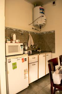 a kitchen with a white refrigerator and a microwave at LOS GURISES Villa Elisa in Villa Elisa