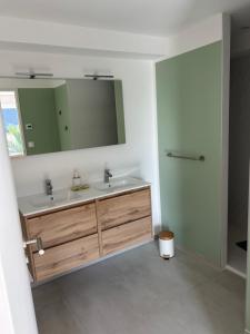 un baño con dos lavabos y un espejo en Le Sillage Vert, en Rosnoën