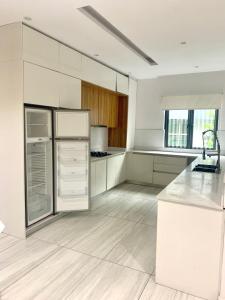 a kitchen with white cabinets and a white refrigerator at The Pelican Lagos in Badore