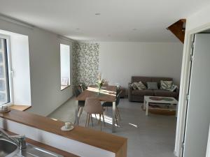 una sala de estar con un sofá y una mesa en Le Sillage Vert, en Rosnoën 5 fotos más