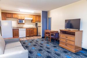 a living room with a couch and a kitchen with a tv at Boerne Inn and Suites in Boerne