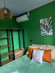 a bedroom with green walls and a bed with pillows at Casa das Oliveiras in Torres