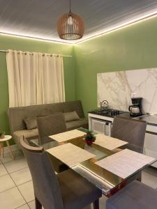 a dining room with a table and a kitchen at Casa das Oliveiras in Torres
