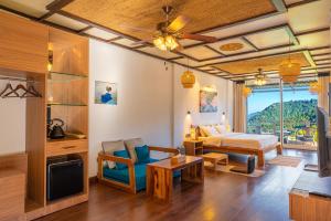 a hotel room with a bed and a living room at The Wild Sakura in Mukteshwar