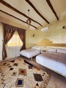 Un dormitorio con dos camas y una gran ventana. en Urti Villa, en Nzala