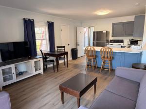 a living room with a couch and a table and a kitchen at Seahawk Motel in Chincoteague
