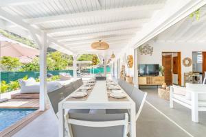 an outdoor dining area with a table and chairs at Villa Bohème in Terre-de-Haut