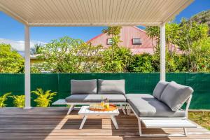 a patio with two couches and a table at Villa Bohème in Terre-de-Haut